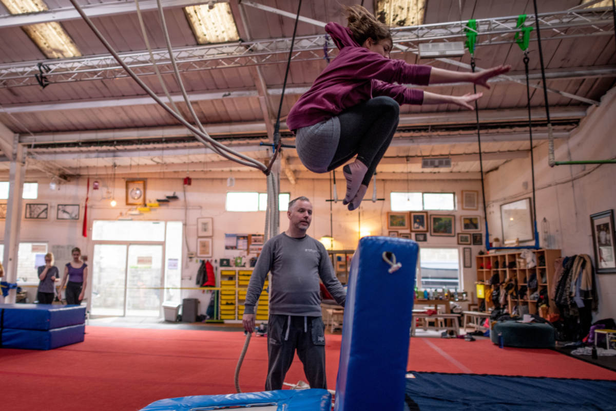 Acrobatic tuck jump from a trampette over a crash mat