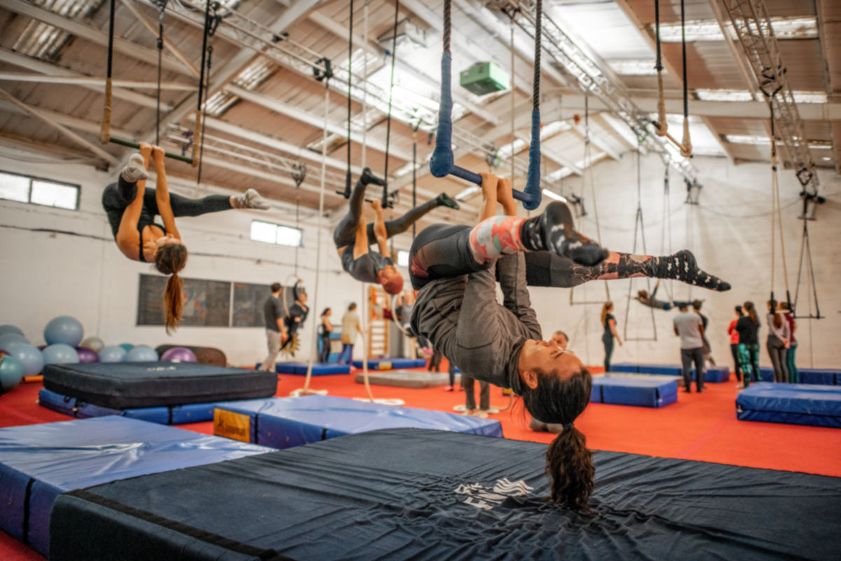 Trapeze artists conditioning straddle under the bar